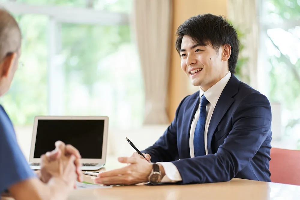 顧客と笑顔で話すビジネスパーソン